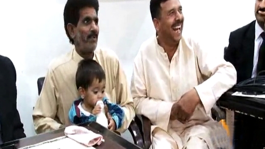 Nine-month-old boy clasping his bottle appears in court accused of planning murder in Pakistan
